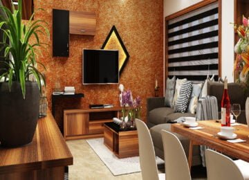 Modern living room interior design with textured accent wall, wooden TV unit and dining area by St Mary’s Interiors Kerala