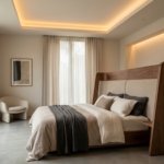 Minimalist master bedroom with a custom curved wooden headboard, tray ceiling lighting, and neutral tones by St. Mary's Wood Crafts Interiors.
