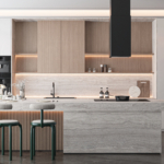 Luxury U-shaped kitchen in Kochi with customized wood-finish upper cabinets, grey base units, and a large window for natural lighting.